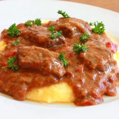 a white plate topped with meat and gravy