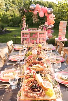 a long table is set up with plates and glasses for an outdoor party or celebration