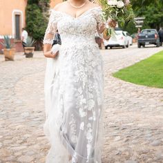 a woman in a wedding dress is walking down the street