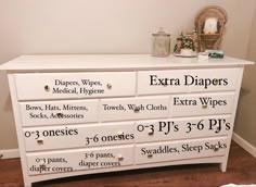 a white dresser with extra diapers written on the top and bottom drawers in different sizes