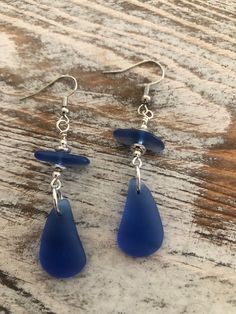 blue sea glass drop earrings on wooden table