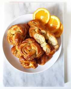 oranges and croissants on a white plate