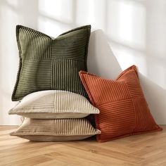 three pillows sitting next to each other on top of a wooden floor