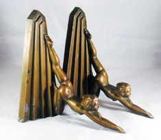 two bronze figurines sitting on top of each other in front of a white background