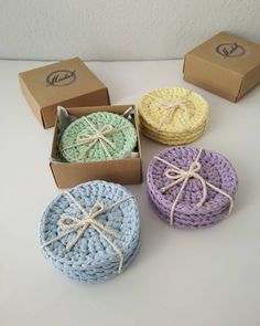 four small crocheted baskets in different colors and sizes, tied with twine