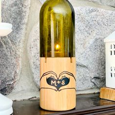 a bottle of wine sitting on top of a wooden shelf next to a candle holder