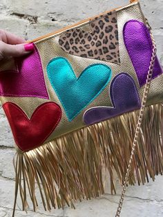 Custom made metallic gold bag with hearts  ❤️Made from metallic gold faux leather fabric  💕 embellished with hearts on both sides of the bag. Choose the colour(s) you would like for the hearts. Choose up to 12 colours, each side will have 6 hearts. Please write the colour(s) you would like in the personalisation box 💚 Embellished with gold faux leather fringe along the bottom of the bag 💙 Choose the size you would like for the bag. The size options are: Xs 21 by 15cms Sm 24 by 17cms Med 27 by Gold Fringe Rectangular Bag, Gold Rectangular Bag With Fringe, Gold Fringe Party Bag, Gold Bag, Heart Bag, Faux Leather Fabric, Leather Fringe, Leather Fabric, Metallic Gold