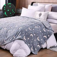 a bed covered in a blanket with stars and moon designs