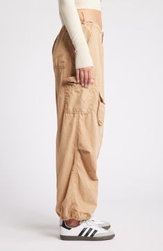 These Y2K-inspired cargo pants feature a baggy low-rise silhouette, plenty of pockets and a toggle-adjustable waist. 29 1/2" inseam; 12" leg opening; 10" front rise; 14 1/2" back rise (size medium) Exclusive retailer Zip fly with hook-and-bar closure Drawcord-toggle waist Front slant pockets; back patch pocket; cargo flap-patch and flap-bellows pockets 100% cotton Machine wash, line dry Made in Turkey Utility Cargo Bottoms With Relaxed Fit, Relaxed Fit Utility Cargo Bottoms, Relaxed Fit Cargo Style Utility Bottoms, Relaxed Fit Straight Leg Parachute Pants With Cargo Pockets, Utility Parachute Pants With Tapered Leg, Utility Parachute Pants With Hip Pockets And Tapered Leg, Relaxed Fit Utility Bottoms, Utility Cargo Pants Full Length For Fall, Fall Utility Parachute Pants With Tapered Leg