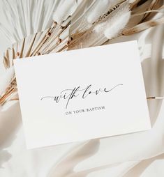 a white card with the words wife on it next to some feathers and a feather fan