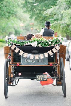 an old fashioned carriage with two people in it