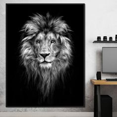 a black and white photo of a lion's face on a wall next to a desk