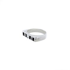 a white ring with black letters on the front and bottom, sitting against a white background