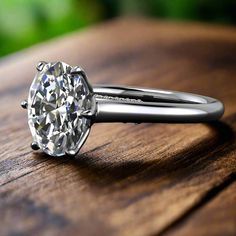 a diamond ring sitting on top of a wooden table