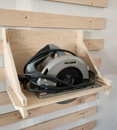 a circular saw is sitting on top of a piece of wood in a storage compartment