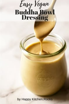 a spoon full of pudding sitting on top of a jar with the words easy vegan buddha bowl dressing