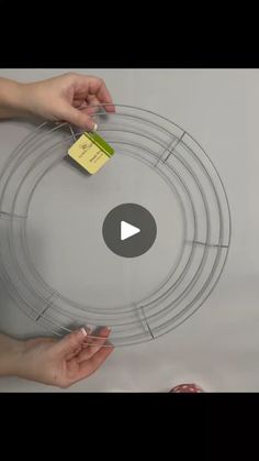 two hands are holding an object in the middle of a circle with tags attached to it