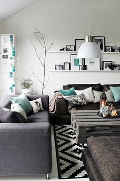 a living room filled with furniture and pictures on the wall next to a coffee table