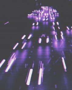 blurry image of street lights in the dark with purple hues and black background