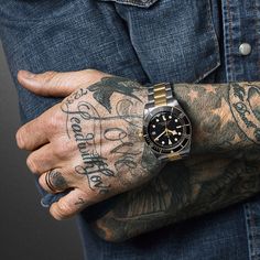 a man with tattoos on his arm and wrist is wearing a watch that reads rolex