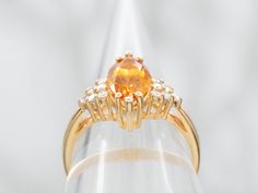 The warm, orange shade of this variety of citrine is absolutely exquisite. This particular piece is an excellent example, full of sparkle and with excellent color. We've set this marquise cut stone into a vintage mounting with sparkling diamond accents on the shoulders. Metal: 14K Yellow GoldGem: Citrine 1.51 CaratsGem Measurements: 11.2 x 5.9 mm, Marquise CutAccents: 12 Diamonds totaling .18 Carats, H-I in Color, SI-I in ClarityRing Size: 6.25Marks: "14K" Stamped on the inside band Orange Citrine Topaz Ring, Orange Topaz Ring With Prong Setting, Orange Topaz Wedding Ring With Center Stone, Orange Diamond Topaz Ring With Center Stone, Oval Orange Topaz Ring With Center Stone, Orange Topaz Ring With Diamond Center Stone, Classic Orange Topaz Ring With Prong Setting, Formal Orange Topaz Ring With Center Stone, Formal Marquise Topaz Ring With Accent Stones