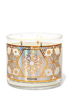 a candle that is sitting in front of a white background with snowflakes on it