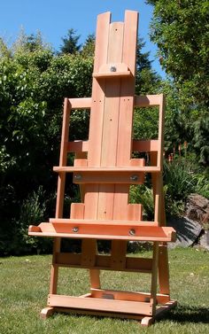 a wooden chair sitting on top of a lush green field