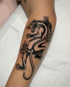 a black and white tattoo on the leg of a person with a lizard in it