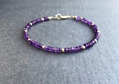 "Amethyst Bracelet Sparkling purple and gold....what's not to like? Genuine amethyst rondelles encircle this bracelet, which is interspersed with 14K gold filled beads. Lobster clasp closure with pretty rope detail ring at clasp. Fashioned on professional quality beading wire for strength and flexibility. A nice addition to your collection. You know -- the one that keeps growing. Unashamedly. Bracelet collectors unite! Faceted rondelles of genuine amethyst, about 3.5-4mm All components 14K gold Elegant Purple Rondelle Beaded Bracelets, Purple Rondelle Beaded Bracelets As Gift, Purple Rondelle Amethyst Bracelets, Purple Amethyst Rondelle Bracelets, Elegant Purple Beaded Bracelets With Gemstones, Amethyst Beaded Bracelets With Spacer Beads As Gift, Purple Rondelle Beaded Gemstone Bracelets, Amethyst Beaded Bracelets With Faceted Beads, Round Amethyst Beaded Bracelets With Faceted Beads