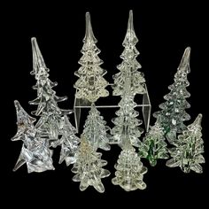 an assortment of glass christmas trees on a black background