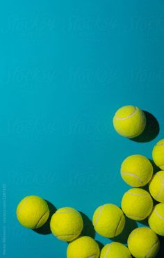 several tennis balls are arranged in the shape of a letter v on a blue background