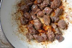 the food is being cooked in the pan on the stove burnered and seasoned with brown stuff