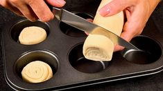 someone is cutting cheese into small muffins in a pan with a large knife