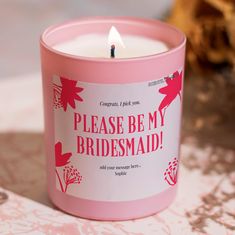 a pink candle that says please be my bridesmaid