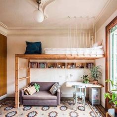 a living room with a couch, desk and bookshelf above the bunk bed