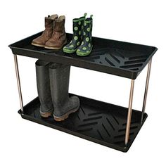 two pairs of rain boots are sitting on a black shelf with metal legs and feet