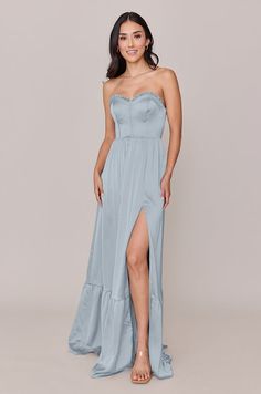 a woman in a strapless blue dress with high slits on the side and one leg