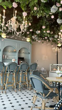 a restaurant with blue chairs and chandeliers hanging from the ceiling