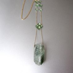 A woven clover of light green emeralds suspends a chunky quartz crystal, covered in sparkling naturally green druse. Six more emeralds accent the fine cable chain. The necklace is 18" and the drop from top of clover to bottom of crystal pendant is 3". The necklace is finished with a spring ring clasp.Check out Jenco Studios at: www.jencostudio.com and www.facebook.com/jencostudios for work in sterling silver, new work previews, info on upcoming sales and signing up for the Jenco Studio mailing l Fine Jewelry With Green Amethyst, One-of-a-kind Green Emerald Jewelry, Unique Green Jewelry With Mineral Crystal, Green Mineral Crystal Pendant Jewelry, Green Amethyst Jewelry With Natural Stones, Green Amethyst Necklace For Gift, Tiffany Stone, 14k Yellow Gold Necklace, Yellow Gold Necklace