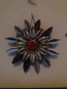 a decorative clock is mounted to the wall with metal leaves on it's face