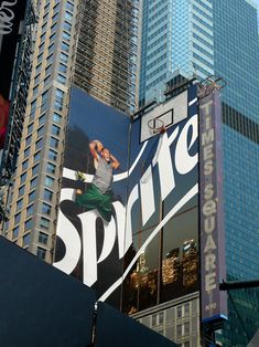 a large advertisement on the side of a building in new york city, with skyscrapers behind it