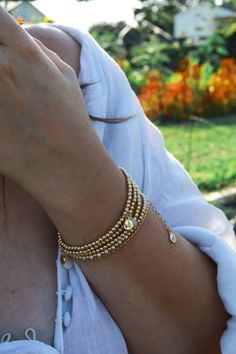 Our Golden Beaded Bracelet is a simple yet radiant addition to any fit representing strength, abundance, and happiness. High-quality 14k Goldfilled beads will last, won't tarnish, and will shine all night long. Choose between one bracelet or layer with our set of two, or stack of three. Golden Beaded Bracelet is handcrafted with 3mm smooth 14k Goldfilled beads on a strong elastic cord. Signature MB gold charm. Each piece is handmade delicately with love and care. All Bracelets are unique and special, variation in color and inclusions in the gemstones are natural. Please take off when swimming, showering, and during hot yoga as water can damage thread. Bathe in moonlight regularly to renew crystals. Enjoy!Light & Love! Spiritual Gold Wrap Bracelet With Round Beads, Elegant Gold Crystal Bracelet For Meditation, Gold Single Strand Spiritual Bracelet, Spiritual Tiny Beads Bracelet, Spiritual Bracelet With Tiny Beads, Gold Beaded Bracelets With Round Beads For Meditation, Spiritual Gold Bangle Wrap Bracelet, Spiritual Gold Wrap Bracelet Bangle, Spiritual Yellow Gold Hand-strung Beaded Bracelets