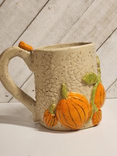 a ceramic mug with pumpkins painted on it