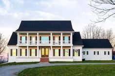 a large white house sitting on top of a lush green field