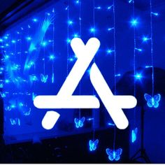 a blue wall with butterflies and lights in the shape of an x on it's side