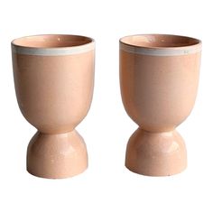 two small cups sitting side by side on top of each other in front of a white background