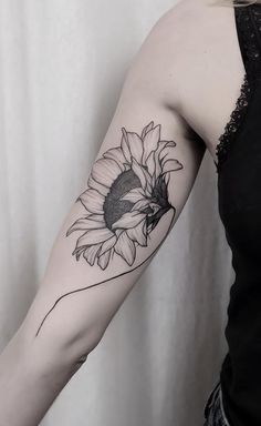 a woman's arm with a sunflower tattoo on the left side of her arm