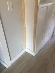 an empty room with white walls and wood flooring on the side, next to a closed closet door