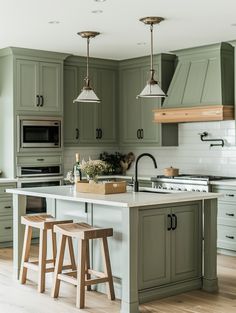 a kitchen with green cabinets and stools