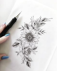 a woman's hand holding a pen and drawing flowers